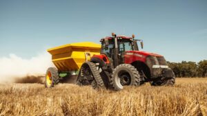 Tractor pulling wagon in wheat field